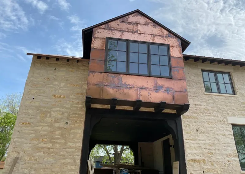 Copper metal panel facade on a stone building for Roof Repair in Kingman